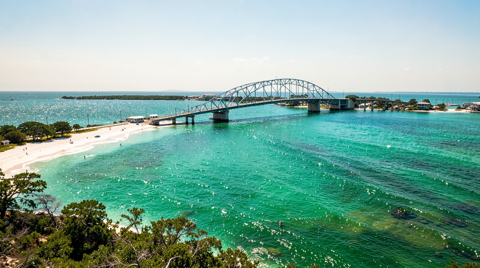 Turquoise Choctawhatchee Bay waters sparkling below the Mid-Bay Bridge as you arrive in Destin Florida on a clear summer afternoon